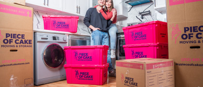 Couple surrounded by packing boxes and crates from Piece of Cake Movers